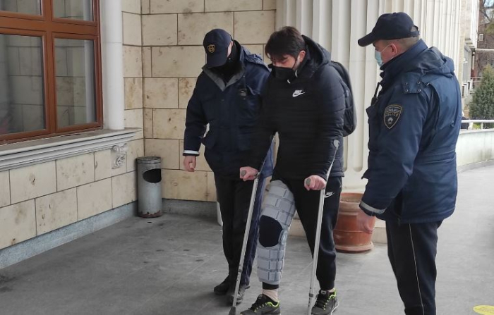 (ВИДЕО) Јанакиески на штаки со повредена нога и легнат во полициско возило однесен на судење